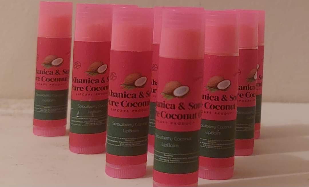 Small tin of coconut lip balm beside a coconut half